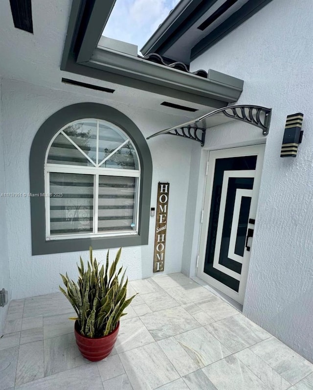 property entrance with stucco siding