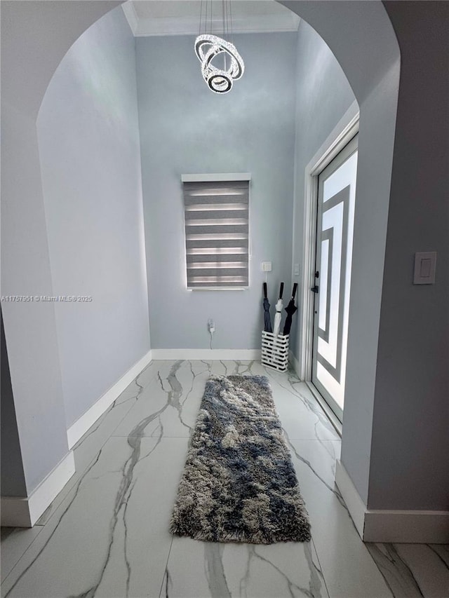 foyer entrance with baseboards, arched walkways, and marble finish floor