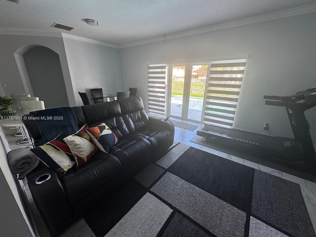 living room with visible vents, arched walkways, and ornamental molding