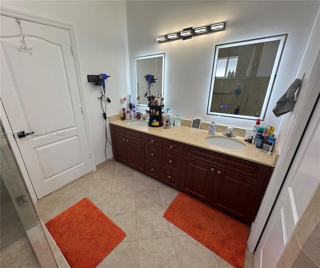 bathroom featuring a sink, tiled shower, double vanity, and tile patterned flooring