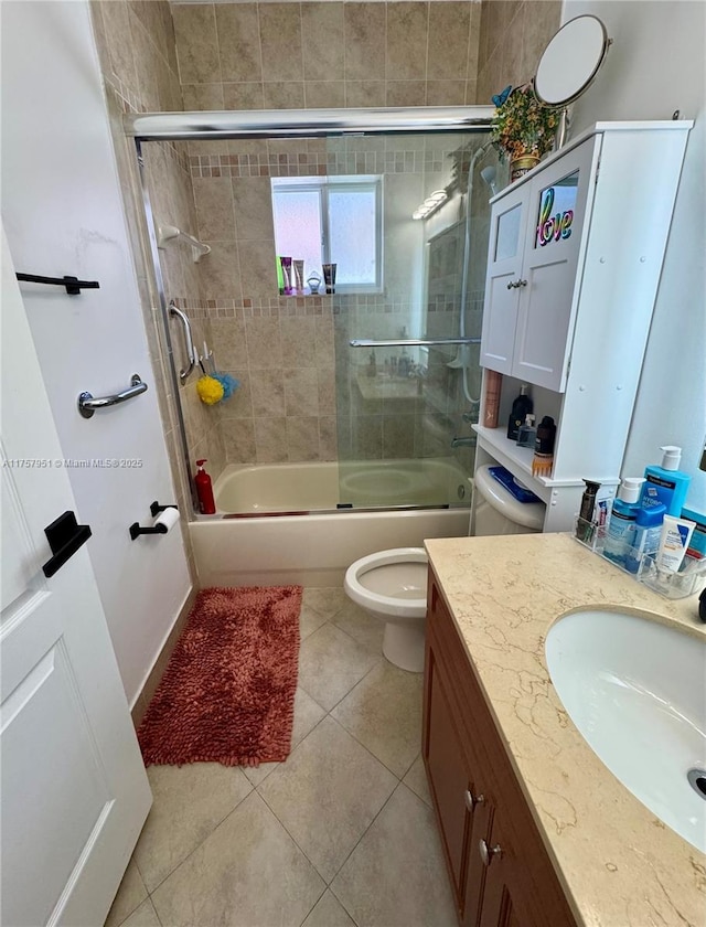 bathroom featuring tile patterned floors, shower / bath combination with glass door, vanity, and toilet