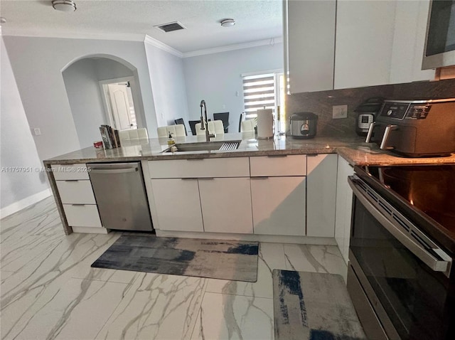 kitchen with a peninsula, a sink, appliances with stainless steel finishes, crown molding, and marble finish floor