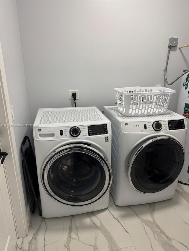 laundry room with laundry area, washing machine and dryer, and marble finish floor