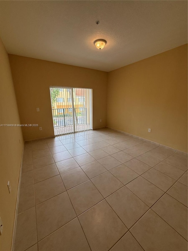 empty room featuring light tile patterned floors and a textured ceiling