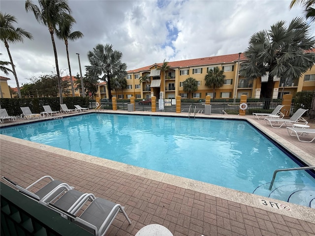 pool with a patio area and fence