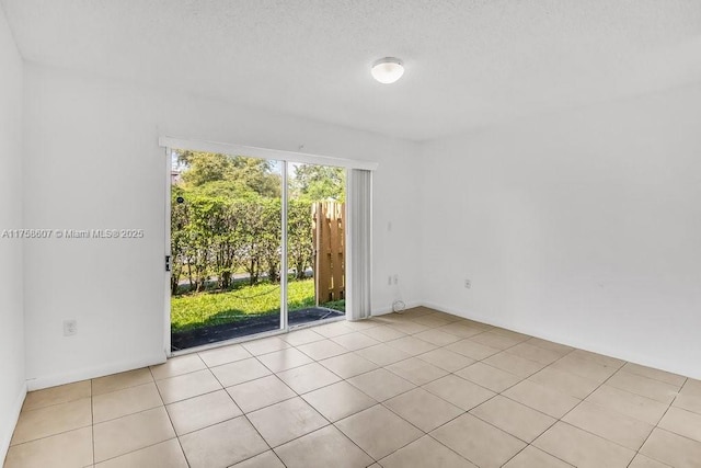 unfurnished room with light tile patterned floors and a textured ceiling