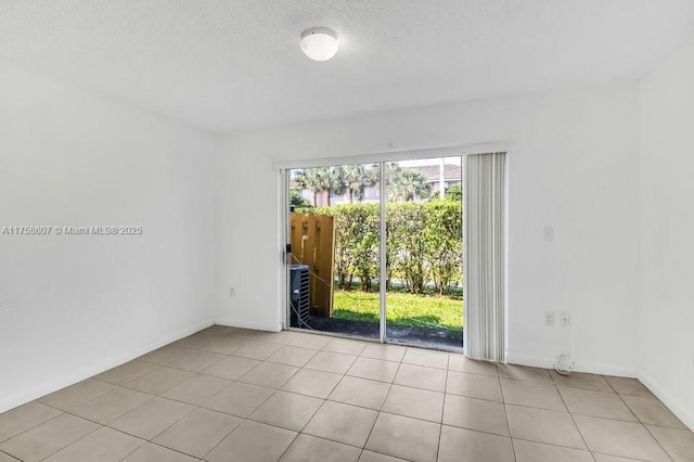 unfurnished room featuring a textured ceiling and tile patterned floors