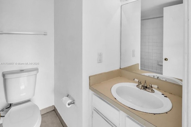 bathroom with vanity, toilet, and baseboards