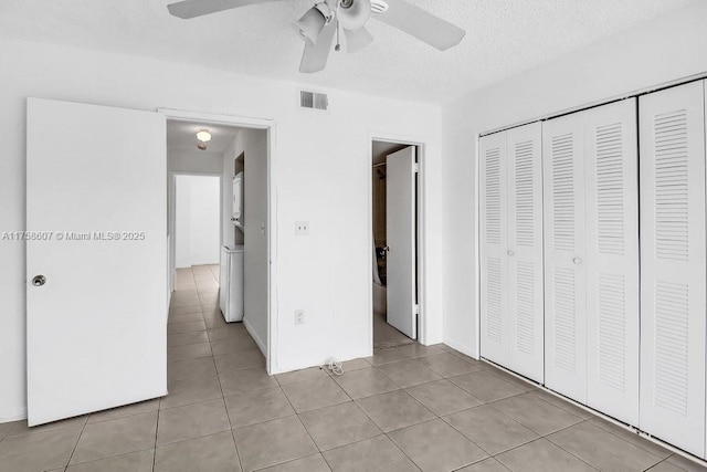 unfurnished bedroom featuring light tile patterned floors, a closet, visible vents, a ceiling fan, and a textured ceiling