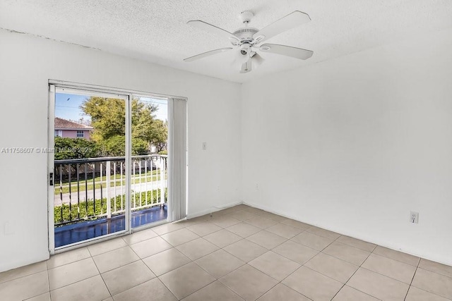 tiled spare room featuring plenty of natural light, ceiling fan, and a textured ceiling