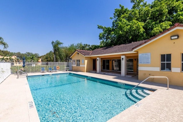 pool with a patio and fence