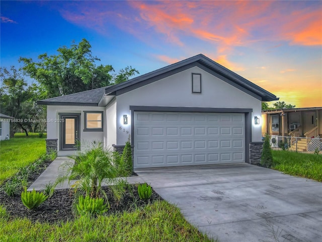 ranch-style house featuring stucco siding, stone siding, concrete driveway, an attached garage, and a shingled roof