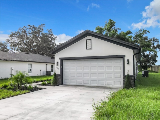 garage featuring concrete driveway and central air condition unit