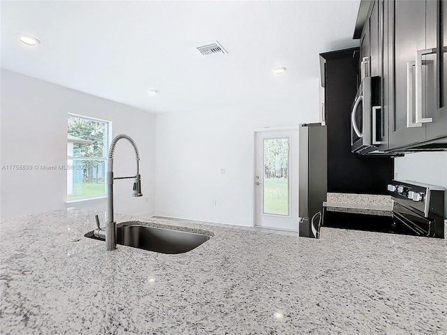 kitchen featuring visible vents, a sink, recessed lighting, appliances with stainless steel finishes, and light stone countertops