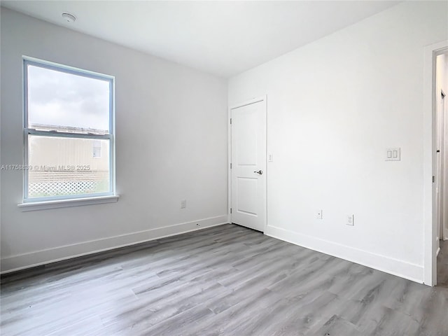 empty room with baseboards and wood finished floors