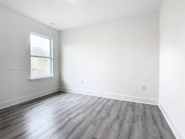 empty room with baseboards and wood finished floors