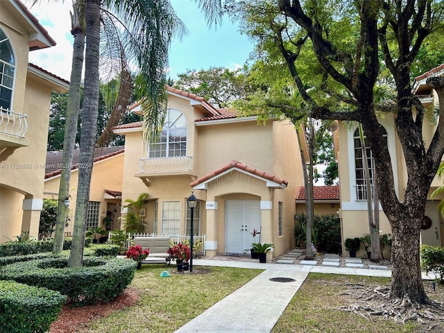 mediterranean / spanish-style house featuring a tiled roof and stucco siding