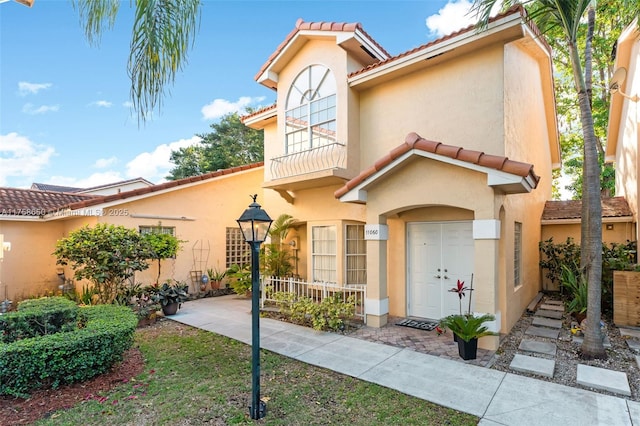 mediterranean / spanish home with a tiled roof and stucco siding