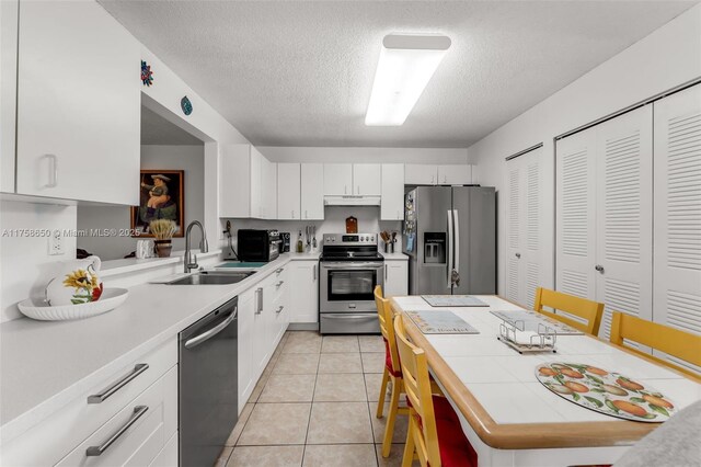 11060 SW 153rd Ct, Miami, FL 33196 - kitchen featuring stainless steel appliances, a sink, under cabinet range hood, light countertops, and a textured ceiling