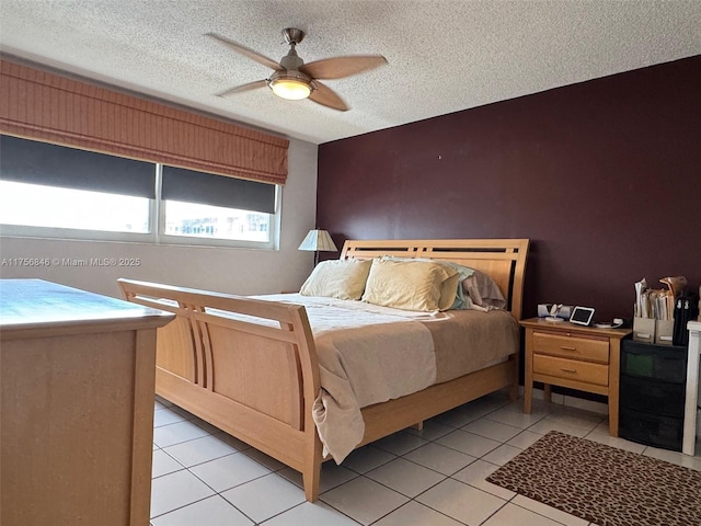 bedroom with light tile patterned floors, ceiling fan, and a textured ceiling