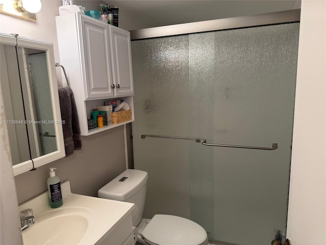 bathroom with toilet, a stall shower, and vanity