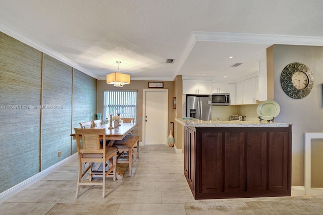 kitchen with visible vents, white cabinets, appliances with stainless steel finishes, light stone counters, and ornamental molding