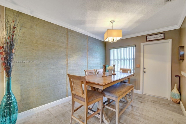 dining area featuring light wood-type flooring, a textured ceiling, baseboards, and crown molding