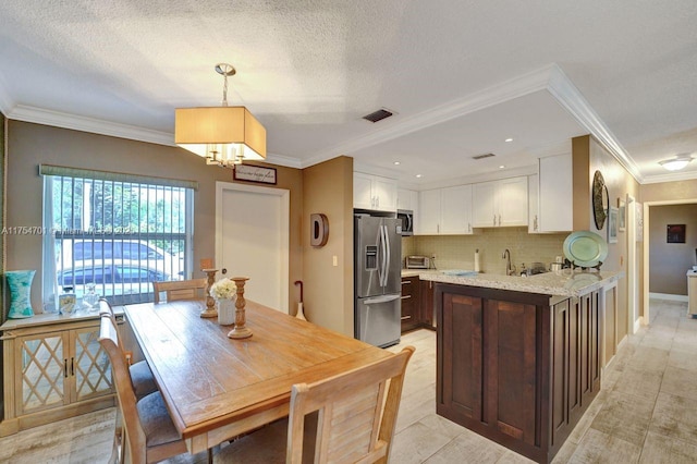 kitchen with tasteful backsplash, visible vents, white cabinets, stainless steel appliances, and a sink