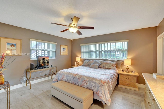 bedroom with ceiling fan, multiple windows, and baseboards