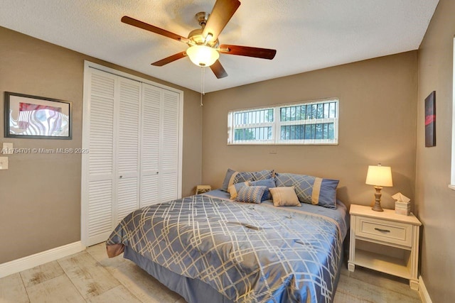 bedroom with a ceiling fan, a closet, baseboards, and wood finished floors