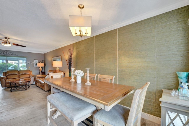 dining room featuring ceiling fan with notable chandelier, light wood-style floors, and crown molding