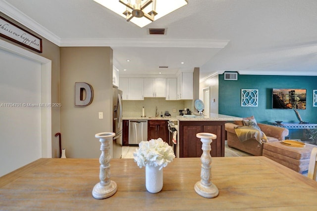 dining room with visible vents and crown molding