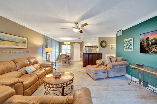 living area featuring baseboards, a textured ceiling, a ceiling fan, and crown molding