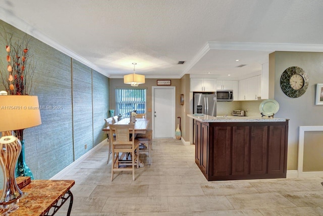 kitchen featuring white cabinets, appliances with stainless steel finishes, light stone counters, ornamental molding, and a textured ceiling