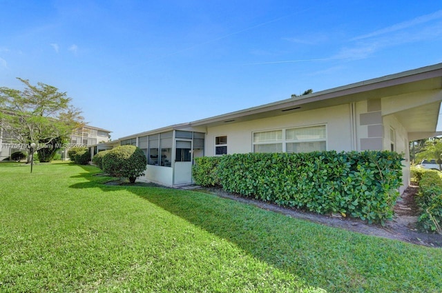 back of property with a lawn and stucco siding