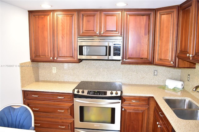 3970 Oaks Clubhouse Dr Unit 307, Pompano Beach, FL 33069 - kitchen featuring appliances with stainless steel finishes, a sink, backsplash, and light stone counters