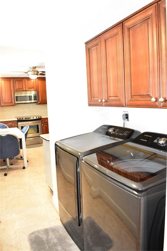 3970 Oaks Clubhouse Dr Unit 307, Pompano Beach, FL 33069 - washroom featuring washing machine and dryer, cabinet space, and light tile patterned floors