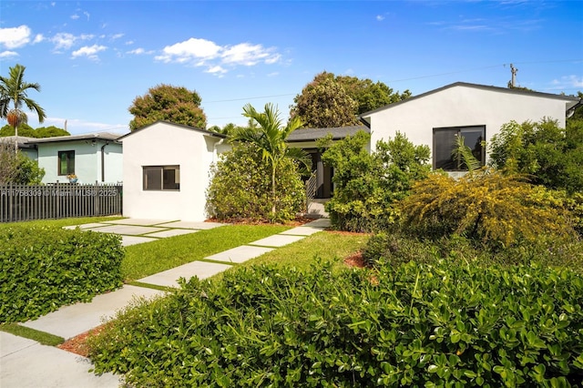 view of front of house with fence and stucco siding