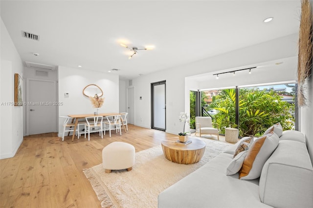 living room featuring light wood finished floors, recessed lighting, visible vents, and baseboards