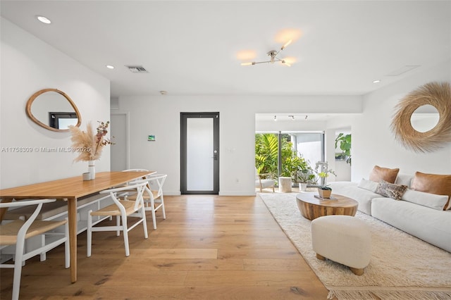 living room featuring light wood finished floors, baseboards, visible vents, and recessed lighting