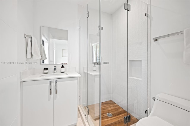 bathroom with a stall shower, visible vents, vanity, and toilet