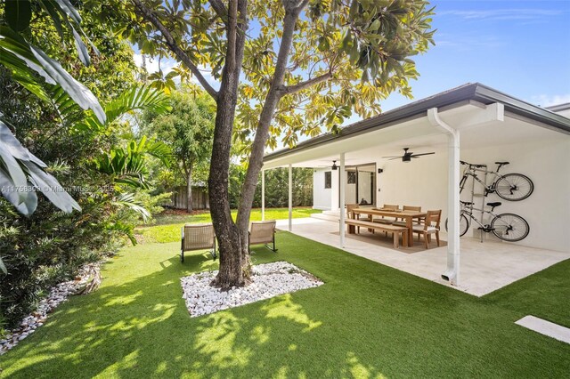 view of yard featuring a patio area, fence, and a ceiling fan