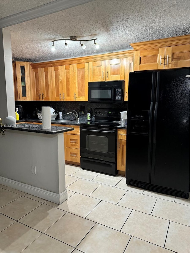 kitchen with light tile patterned floors, a textured ceiling, a sink, backsplash, and black appliances