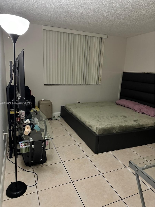 bedroom featuring tile patterned flooring and a textured ceiling