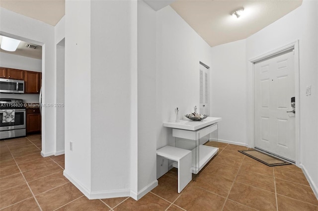 entryway with light tile patterned floors, visible vents, and baseboards