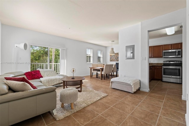 living room featuring electric panel, light tile patterned floors, and baseboards