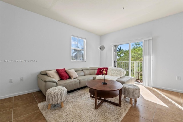 living room featuring tile patterned flooring, plenty of natural light, and baseboards