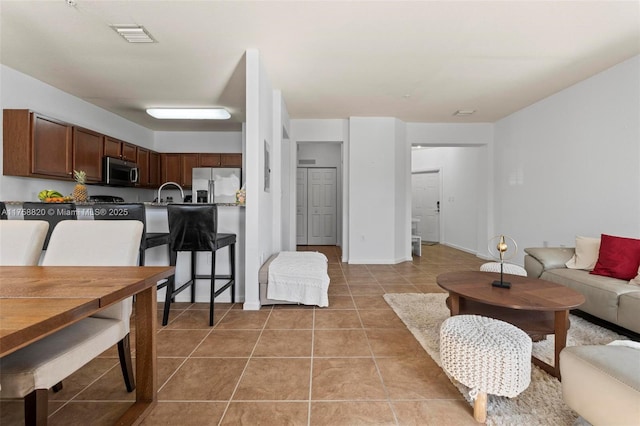 living room featuring light tile patterned flooring and visible vents