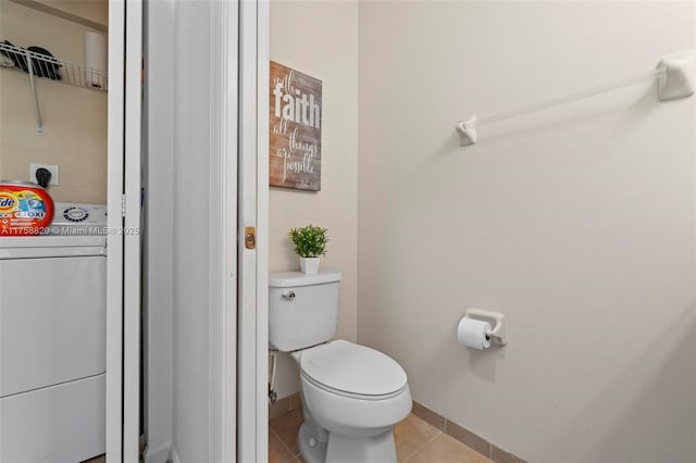 bathroom featuring tile patterned flooring, washer / dryer, toilet, and baseboards