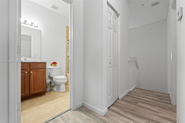 bathroom featuring visible vents, toilet, vanity, and wood finished floors